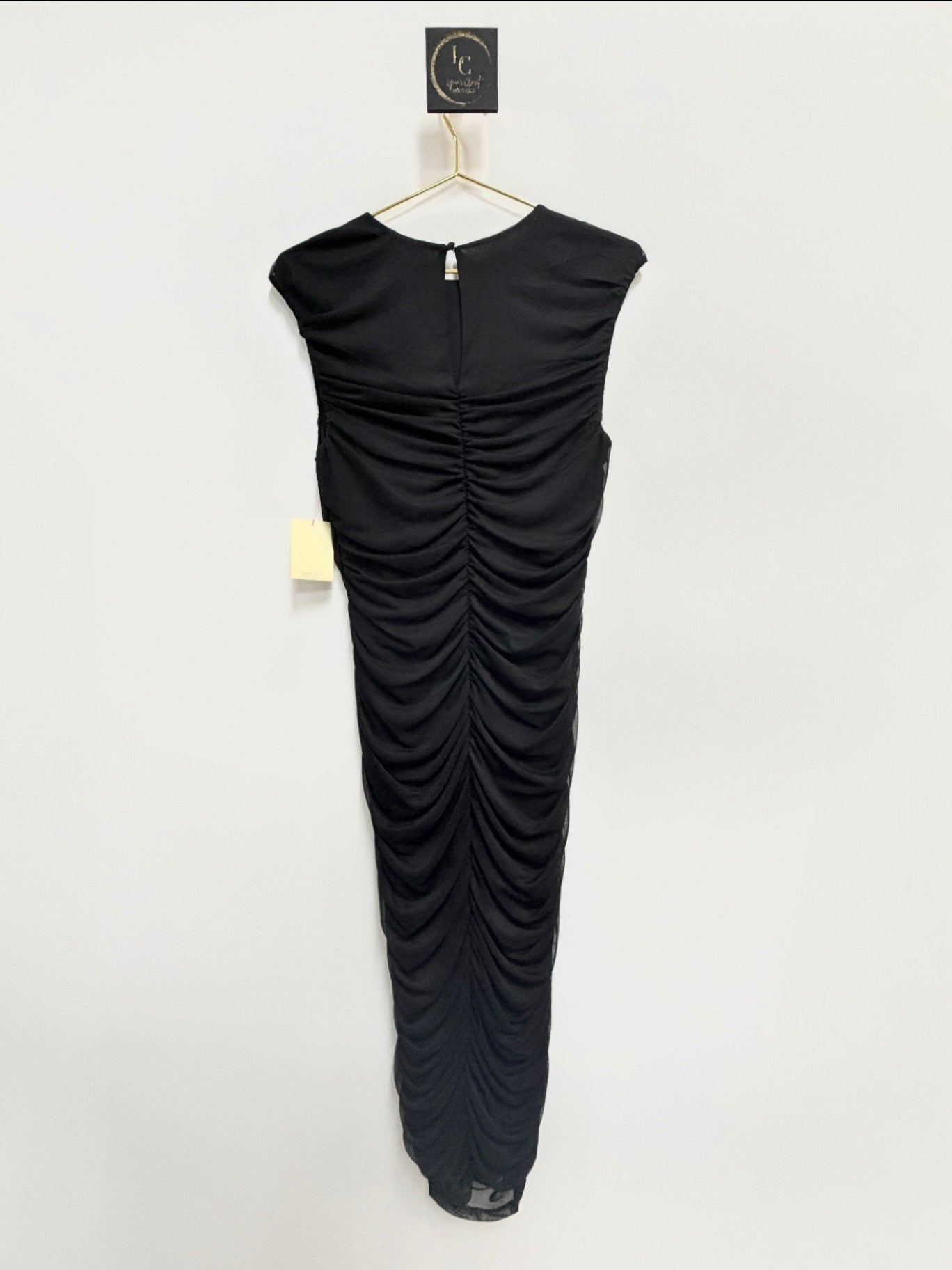 Lynn's Closet Boutique Bar III black sleeveless maxi dress with all-over ruched detailing on a gold hanger.