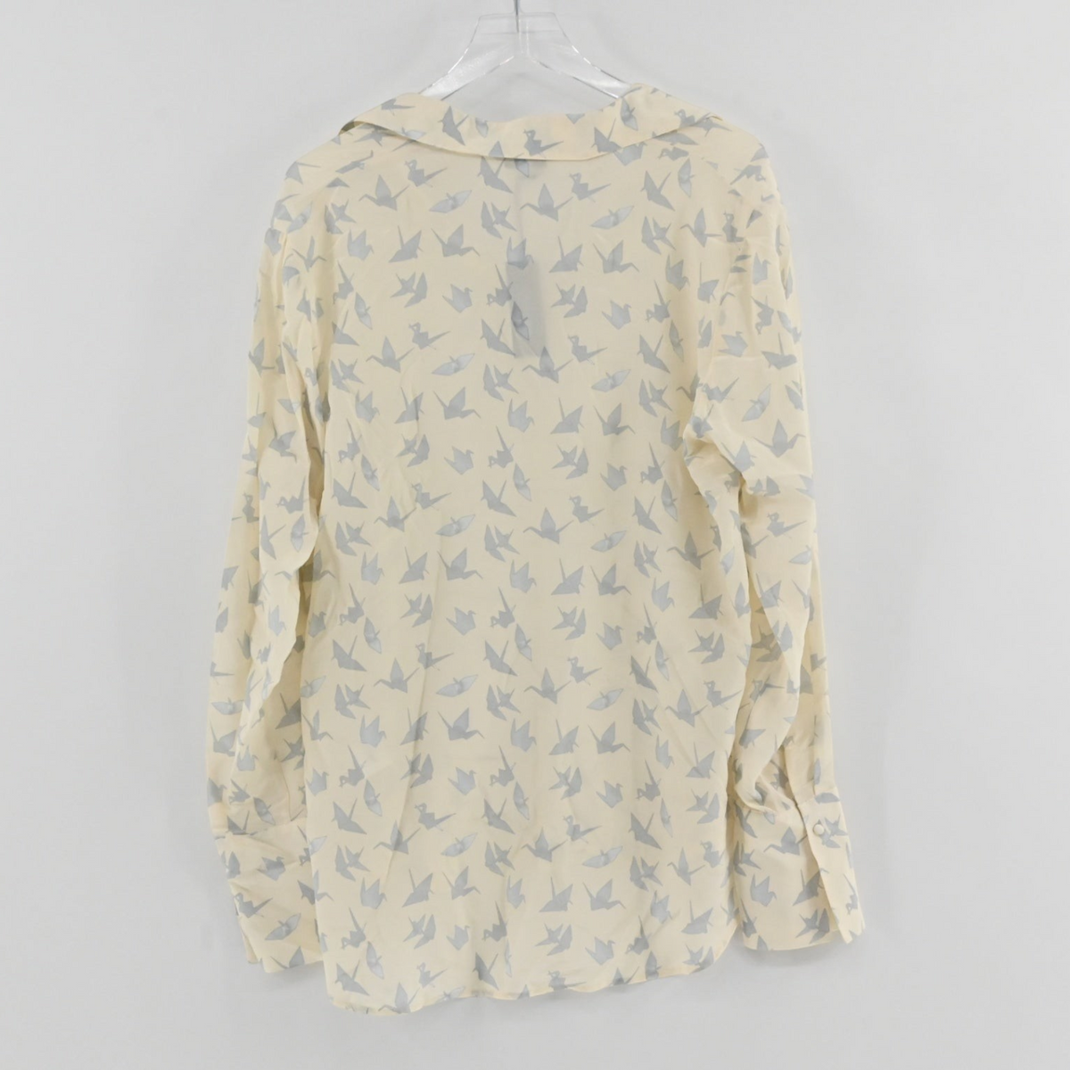 Lynn's Closet Boutique Catherine Gee long-sleeve blouse in cream with a grey origami crane print and button cuffs.