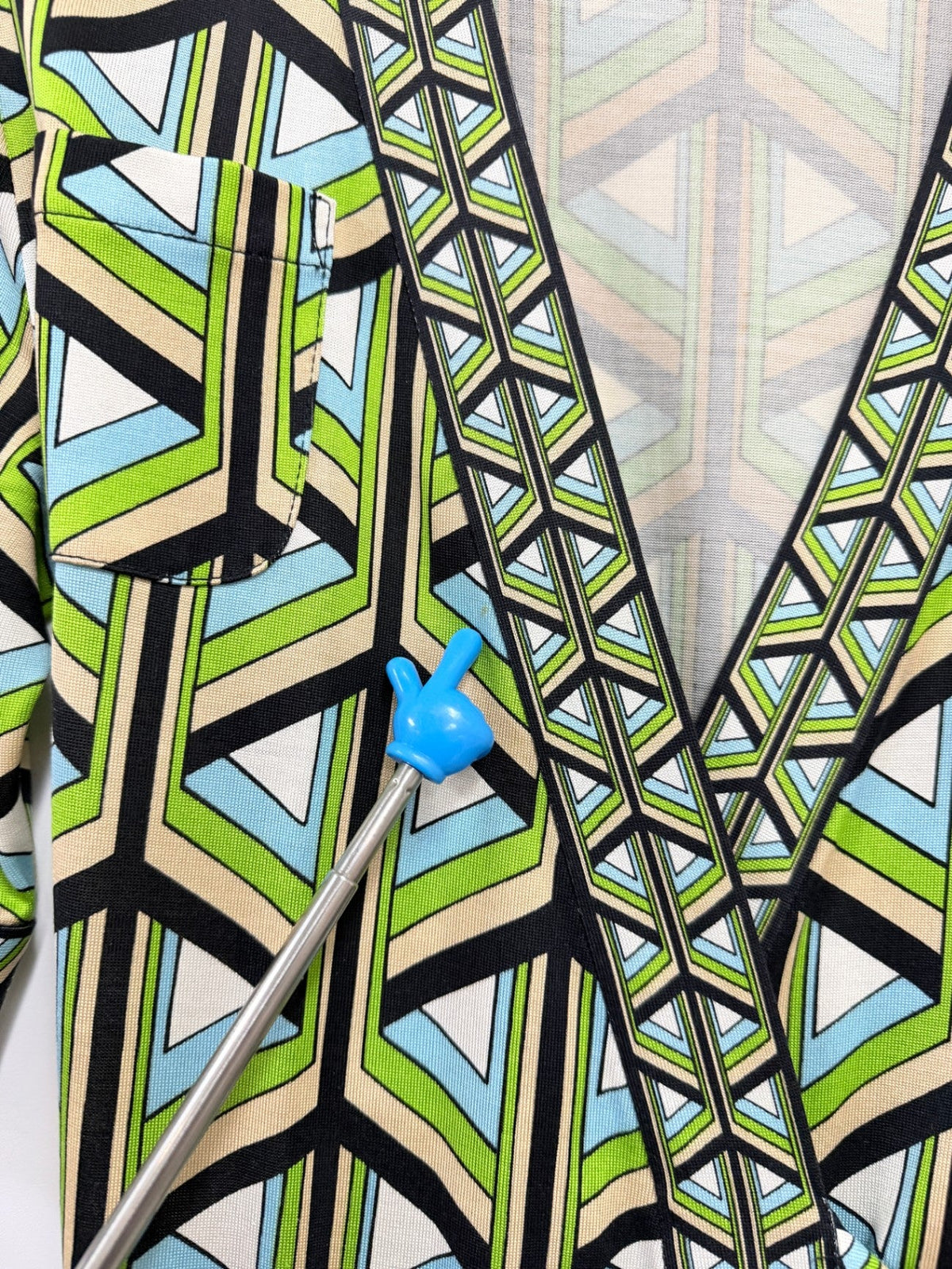 Lynn's Closet Boutique DVF silk wrap top with green, blue, and cream geometric print showing neck area detail