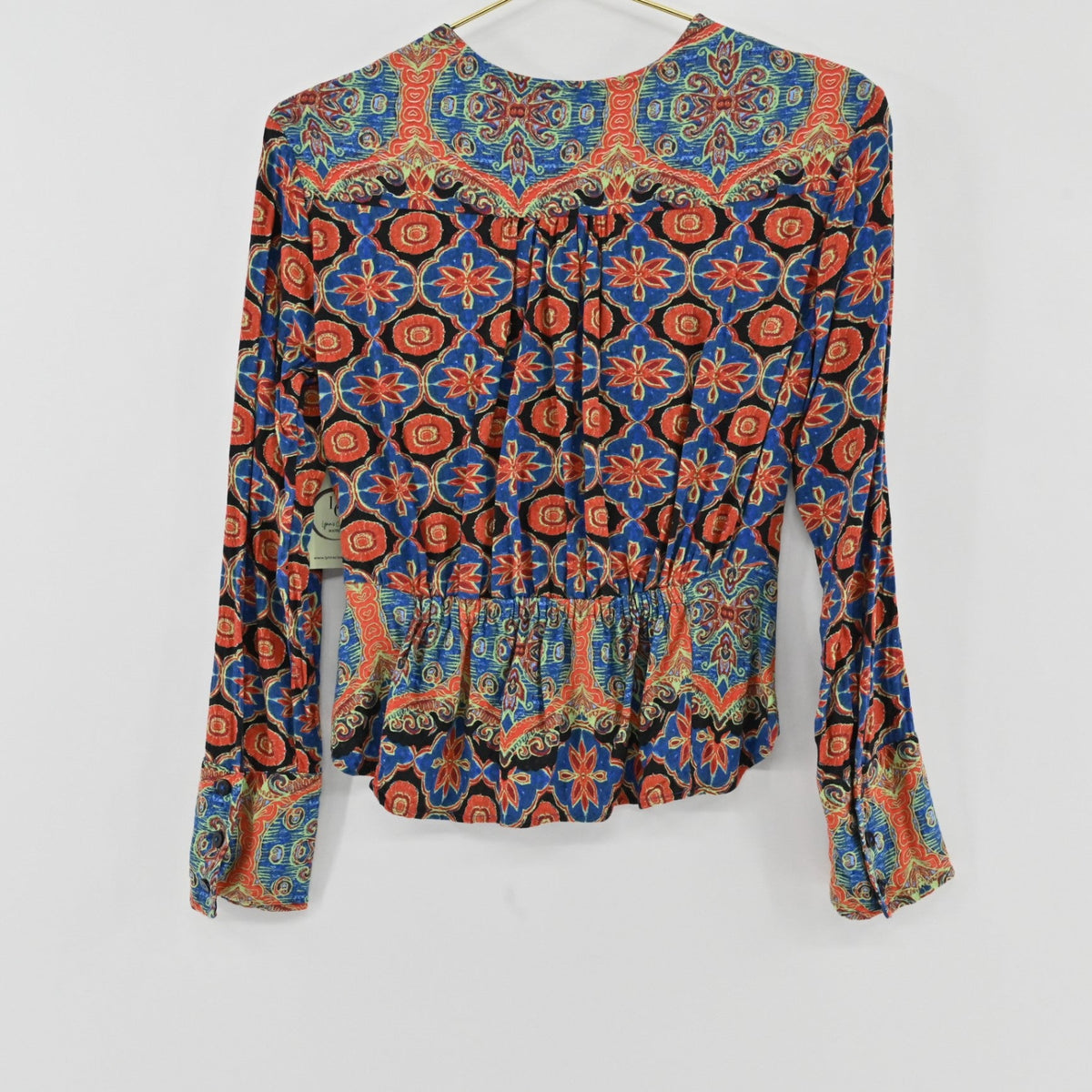 Back view of Lynn's Closet Boutique Free People long-sleeve top with a vibrant multi-colored floral paisley print.