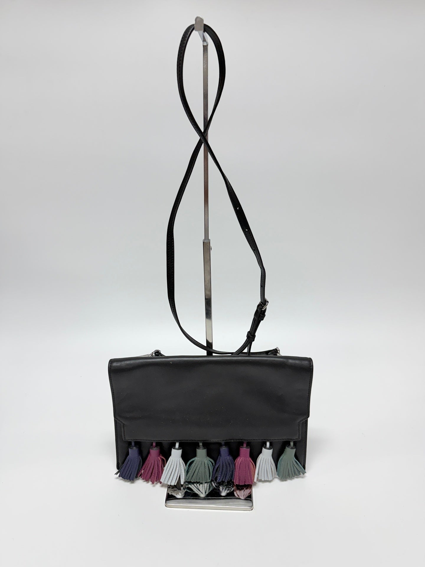 Lynn's Closet Boutique Rebecca Minkoff Sofia black leather clutch with multi-colored suede tassels on a display stand