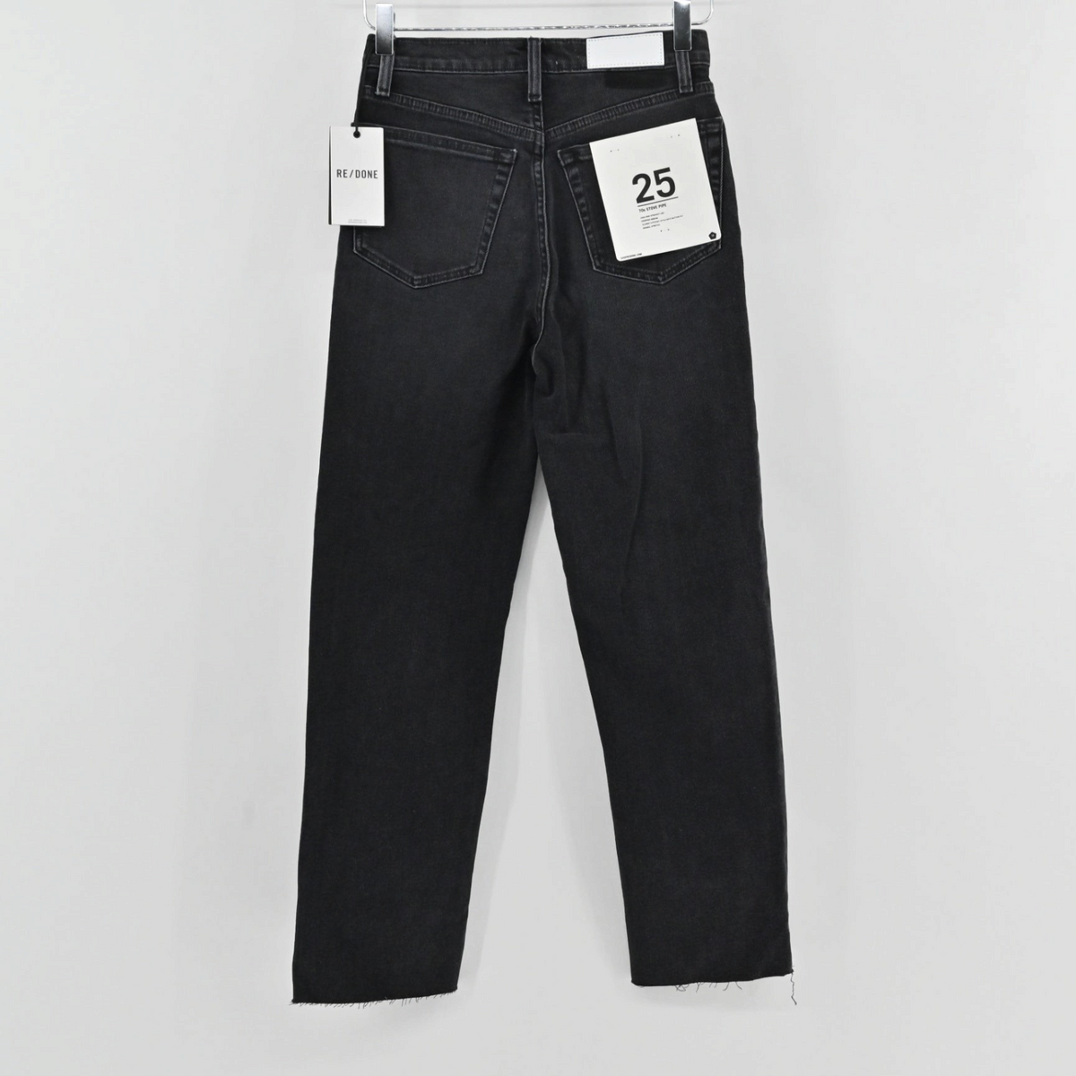 Lynn's Closet Boutique Re/Done 70's Stove Pipe jeans in washed black denim with a raw hem, back view.