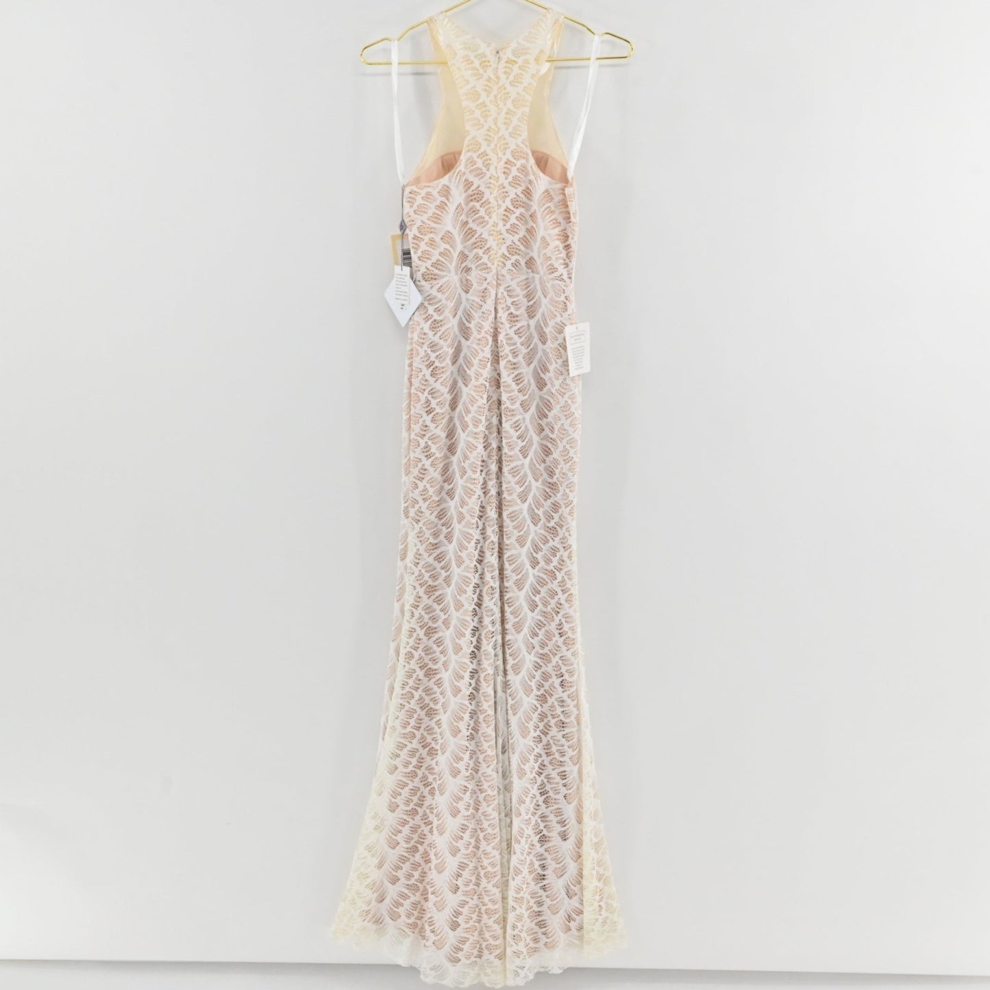Lynn's Closet Boutique Glow Colors white floor-length lace gown with racerback and leaf-patterned overlay on hanger