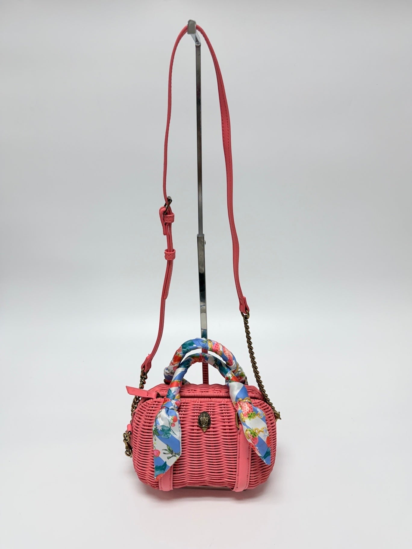 Lynn's Closet Boutique Kurt Geiger coral woven basket Boston bag with eagle emblem and strawberry print scarf handle.