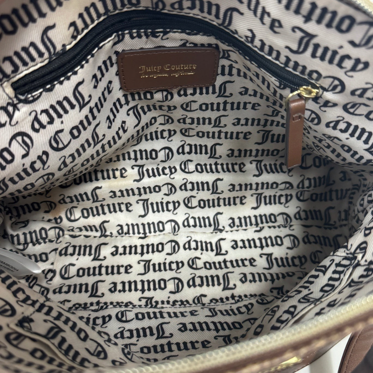 Interior of a Lynn's Closet Boutique Juicy Couture satchel featuring branded fabric lining and a leather logo patch.