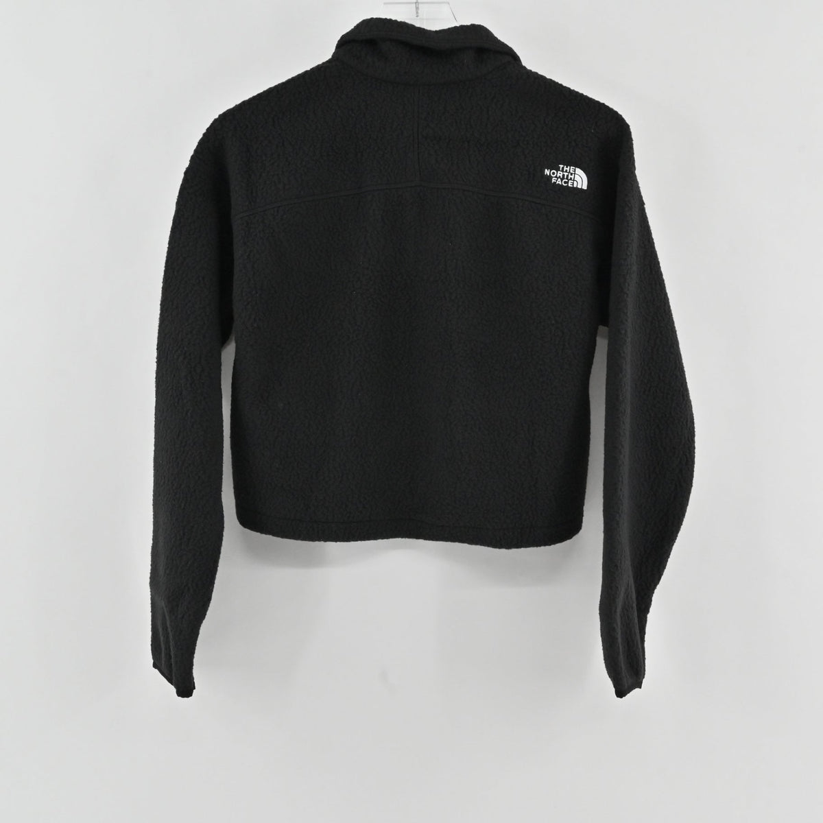 Back view of a black Lynn's Closet Boutique The North Face cropped quarter-zip fleece with white logo embroidery.
