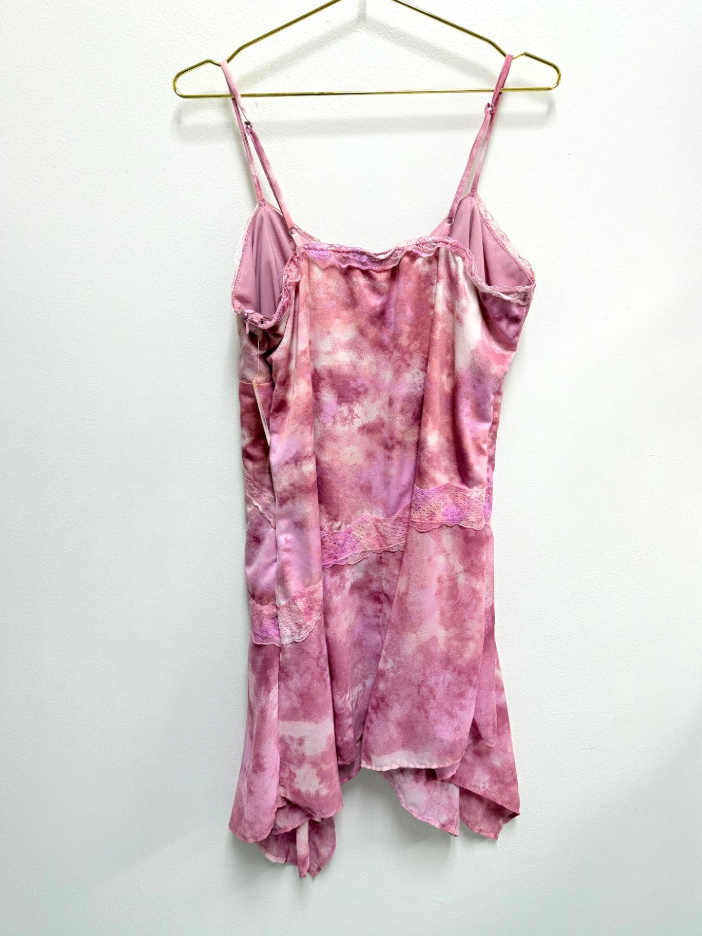 Lynn's Closet Boutique Wild Fable pink tie-dye asymmetrical dress with lace trim and spaghetti straps on a hanger