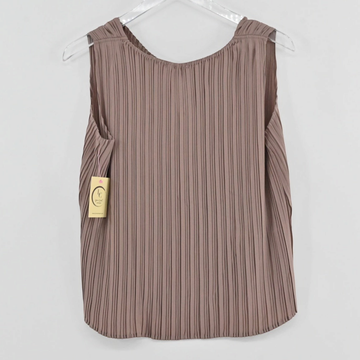 Lynn's Closet Boutique tan sleeveless pleated top with a relaxed silhouette hanging on a clear hanger