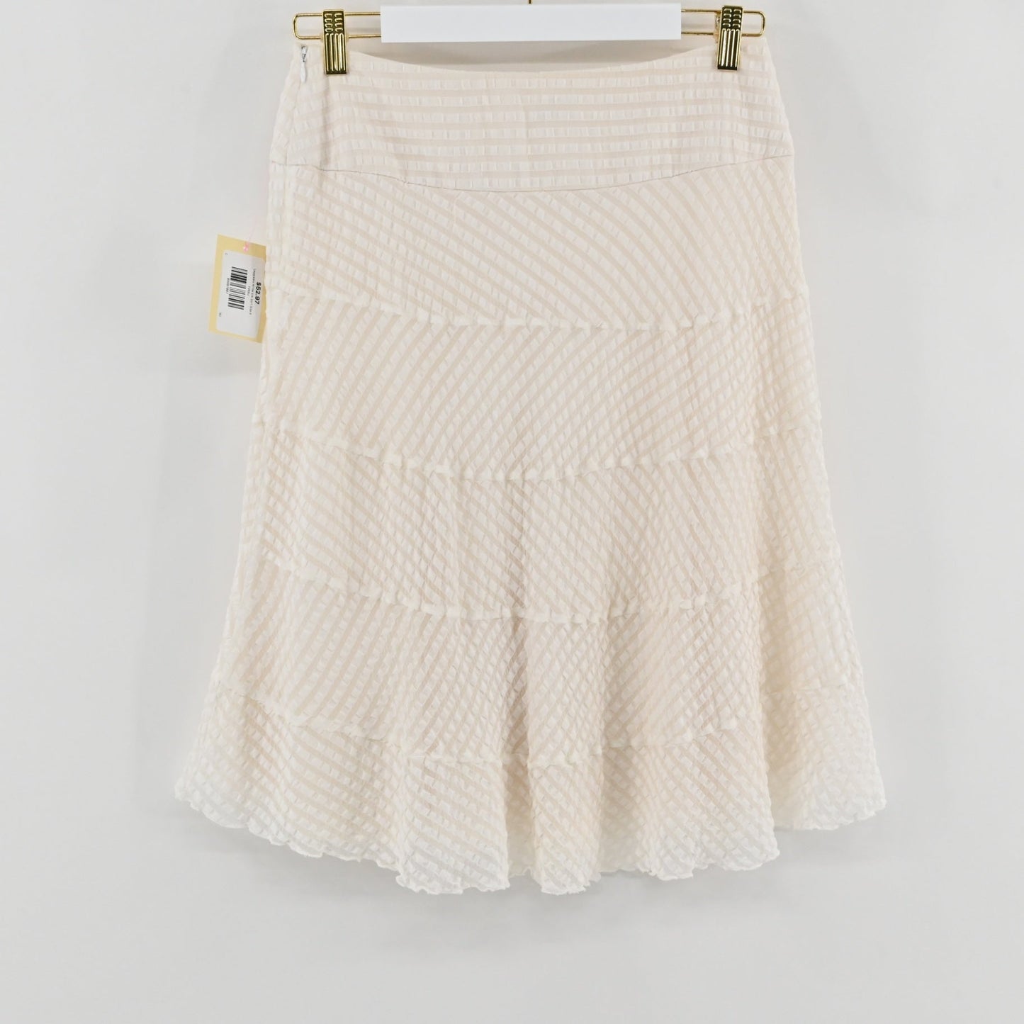 Lynn's Closet Boutique Leggiadro white silk skirt with textured tiered detailing hanging on a white hanger