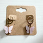 Gold huggie earrings with pink butterfly drop