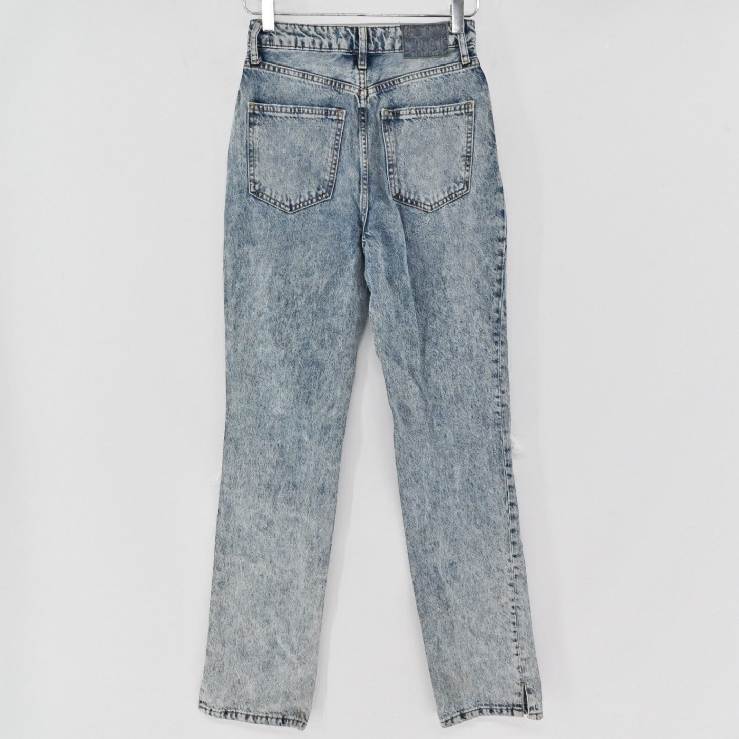 Lynn's Closet Boutique Free People light-wash acid-wash straight-leg denim jeans with back pockets and hem slits.