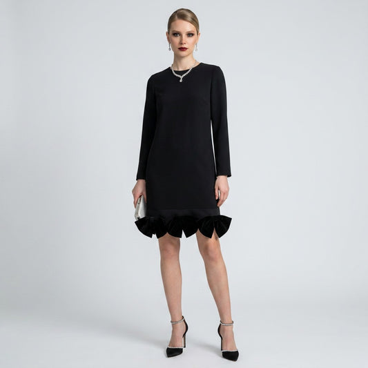 Lynn's Closet Boutique Akira black long-sleeve shift dress with velvet bow hem detail worn by a model