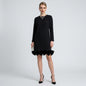 Lynn's Closet Boutique Akira black long-sleeve shift dress with velvet bow hem detail worn by a model