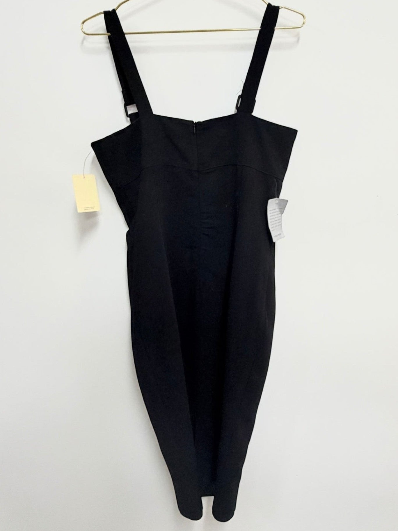 Lynn's Closet Boutique black bodycon midi dress with a square neckline and wide straps hanging on a gold hanger.