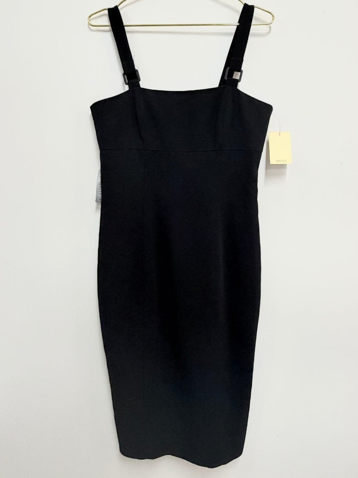 Lynn's Closet Boutique black bodycon midi dress with a square neckline and wide straps, hanging on a hanger.