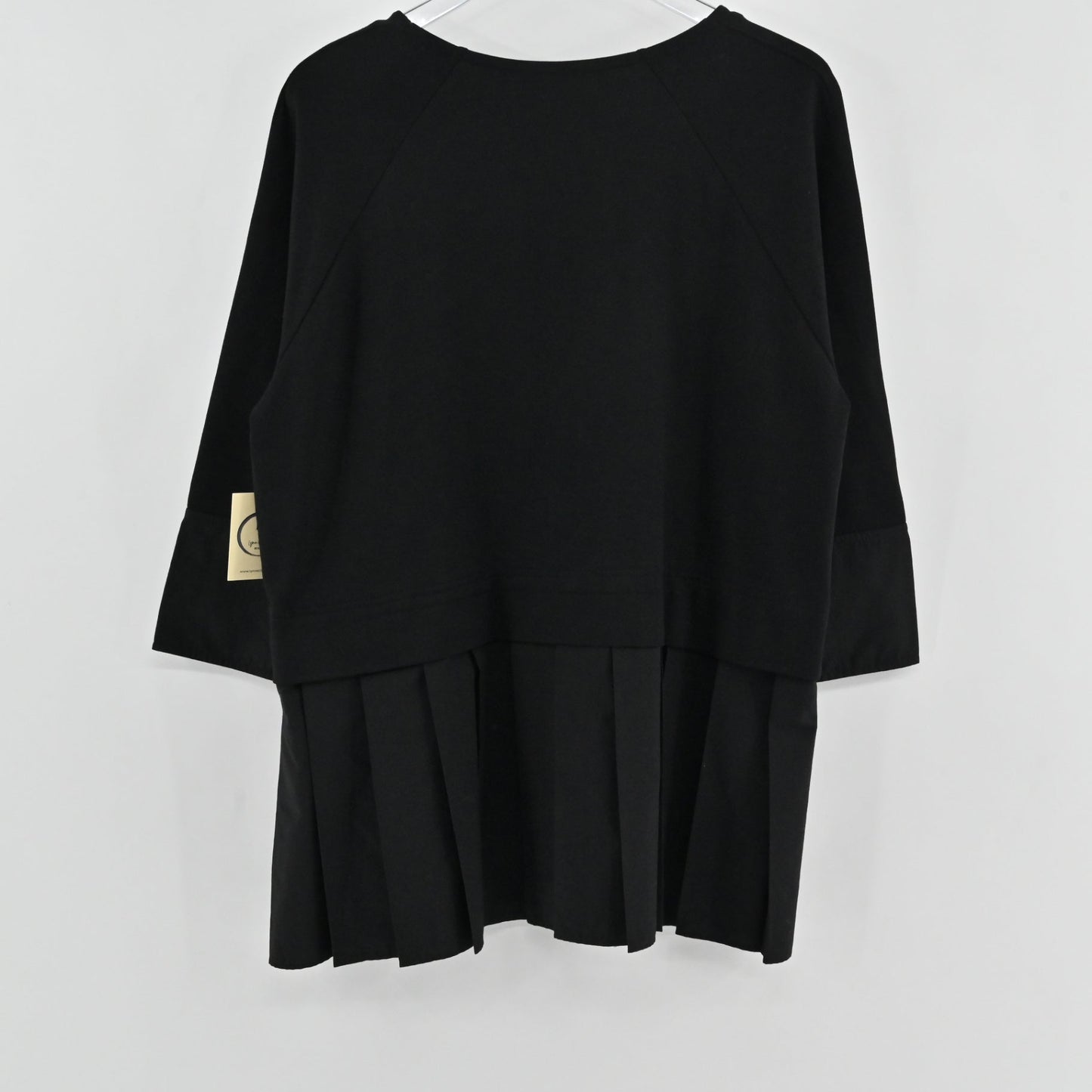 Lynn's Closet Boutique black COS peplum top with three-quarter raglan sleeves and a pleated hem, back view.