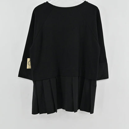 Lynn's Closet Boutique black COS peplum top with three-quarter raglan sleeves and a pleated hem, back view.