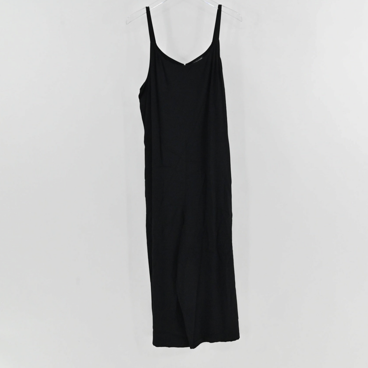 Lynn's Closet Boutique Eileen Fisher black sleeveless jumpsuit with a V-neckline and spaghetti straps on a hanger.