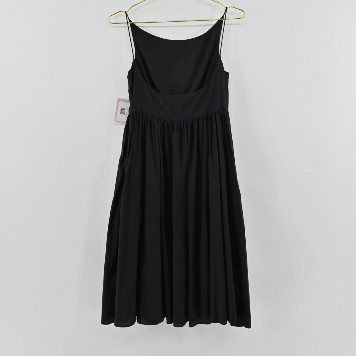 Lynn's Closet Boutique black midi dress with spaghetti straps and a gathered waist, shown hanging on a gold hanger.