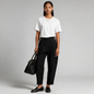 Model wearing Lynn's Closet Boutique Tanya Taylor black high-waisted sailor pants with button details and cuffed hems.