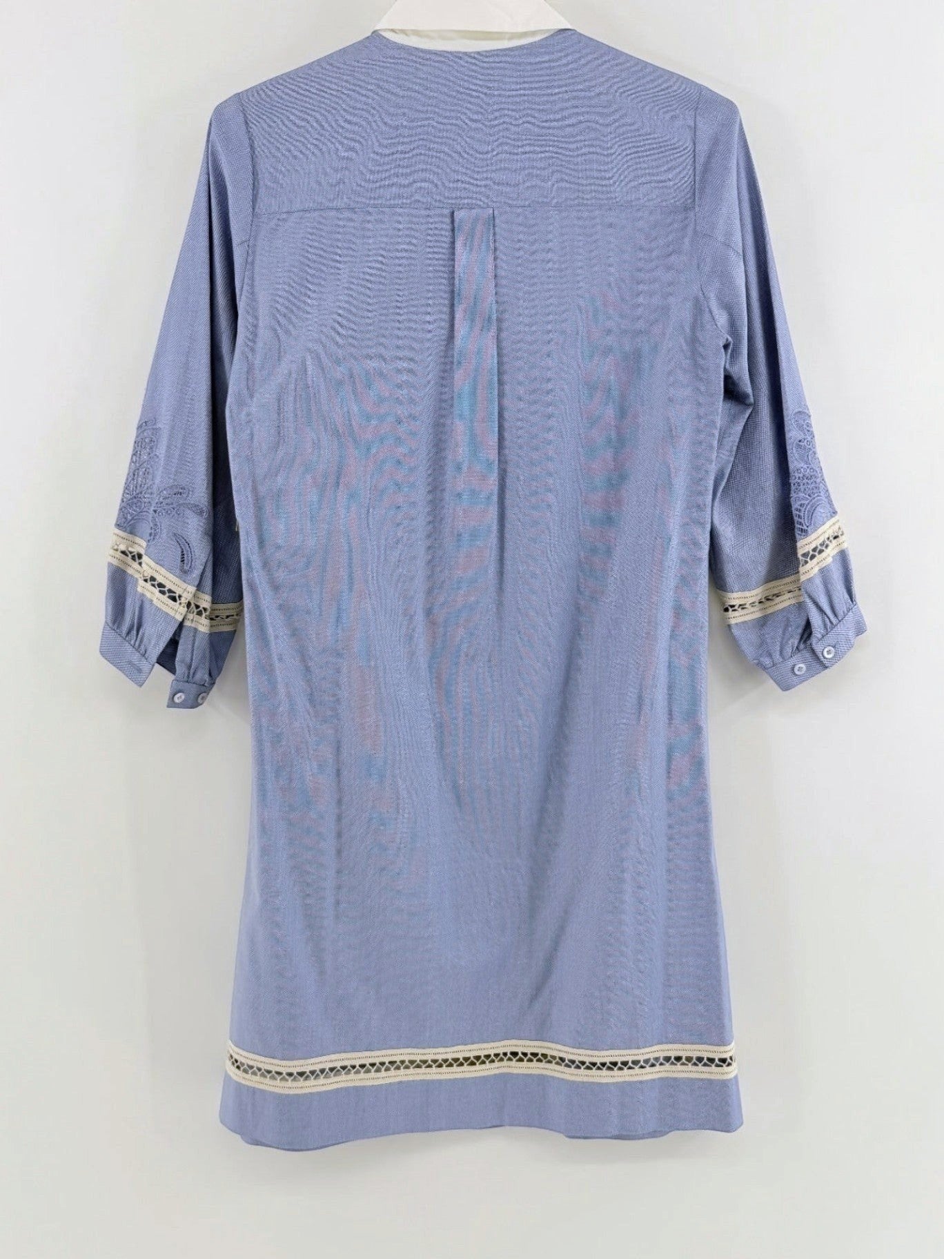 Back view of a Lynn's Closet Boutique blue chambray dress with white collar, lace trim, and embroidered sleeves.