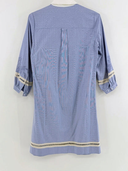 Back view of a Lynn's Closet Boutique blue chambray dress with white collar, lace trim, and embroidered sleeves.