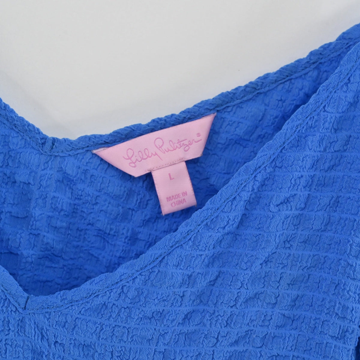 Lynn's Closet Boutique Lilly Pulitzer Aletta top featuring a blue textured seersucker fabric and size L label