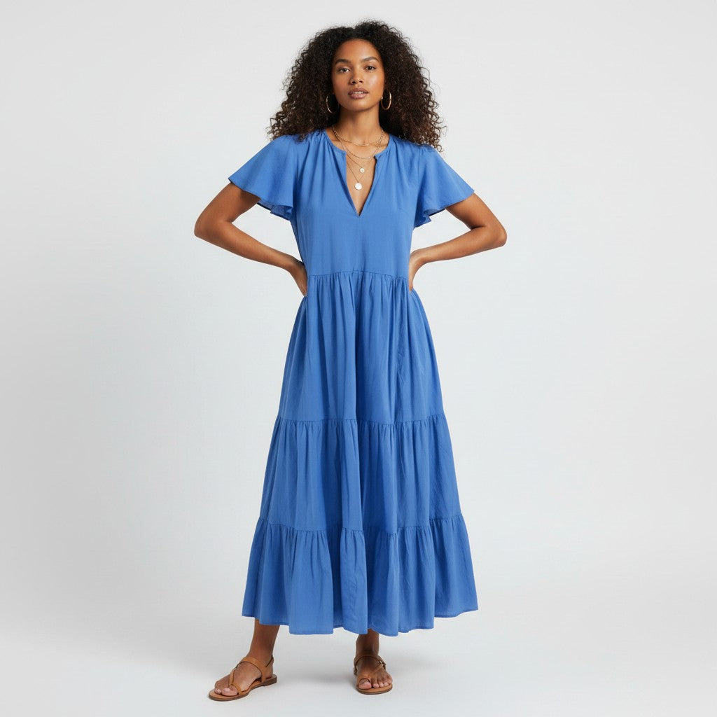 Model wearing a blue Lynn's Closet Boutique tiered midi dress with flutter sleeves and a V-neckline.