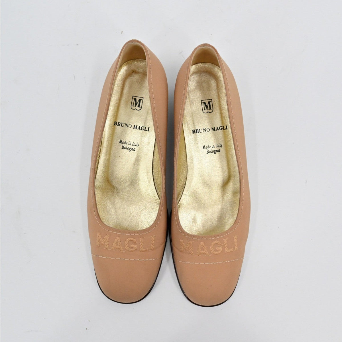 Lynn's Closet Boutique Bruno Magli tan leather loafer pumps with embossed logo and gold interior, top view.