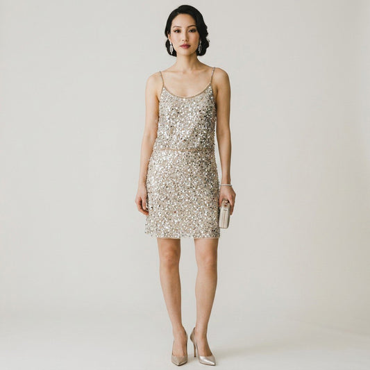 Model wearing a Lynn's Closet Boutique Anthropologie Verb champagne sequin mini dress with spaghetti straps