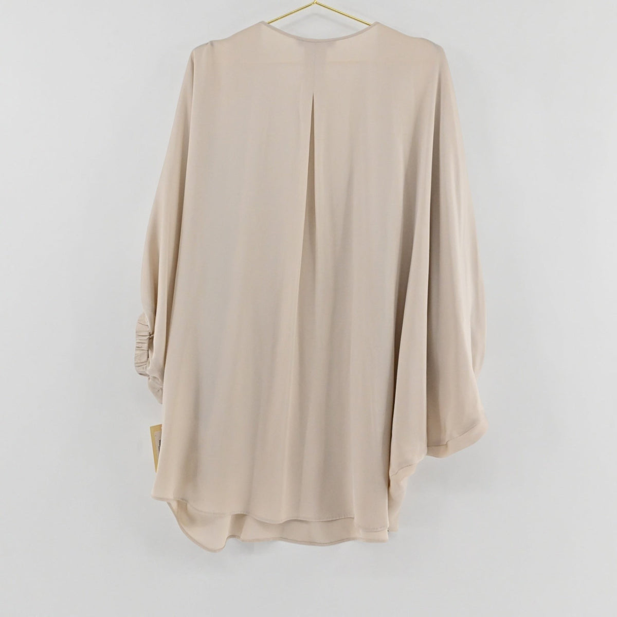 Lynn's Closet Boutique champagne silk top with a relaxed fit, billowy sleeves, and a back pleat, hanging view.