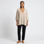Model wearing a Lynn's Closet Boutique champagne silk V-neck top with billowy sleeves and black trousers