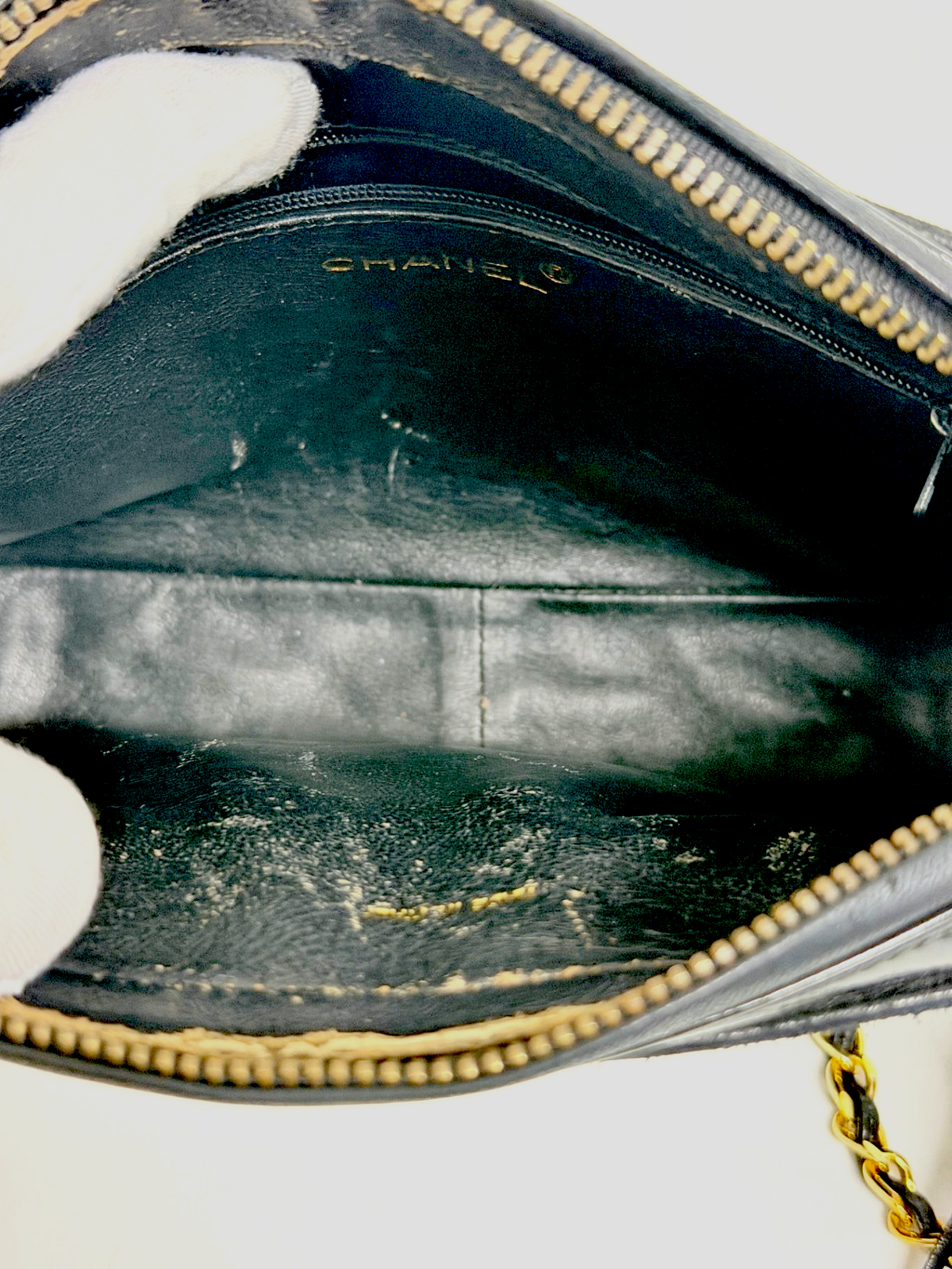 Interior of Lynn's Closet Boutique vintage Chanel camera bag showing black leather lining and gold Chanel logo stamp