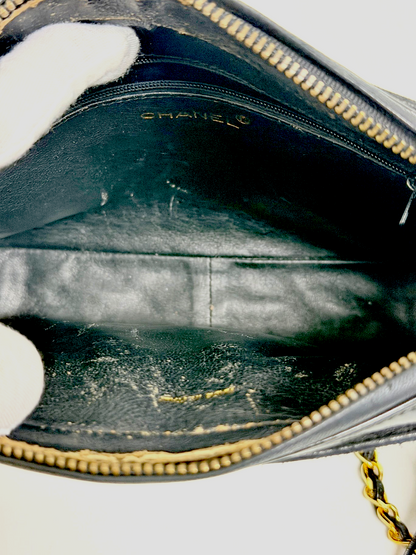 Interior of Lynn's Closet Boutique vintage Chanel camera bag showing black leather lining and gold Chanel logo stamp