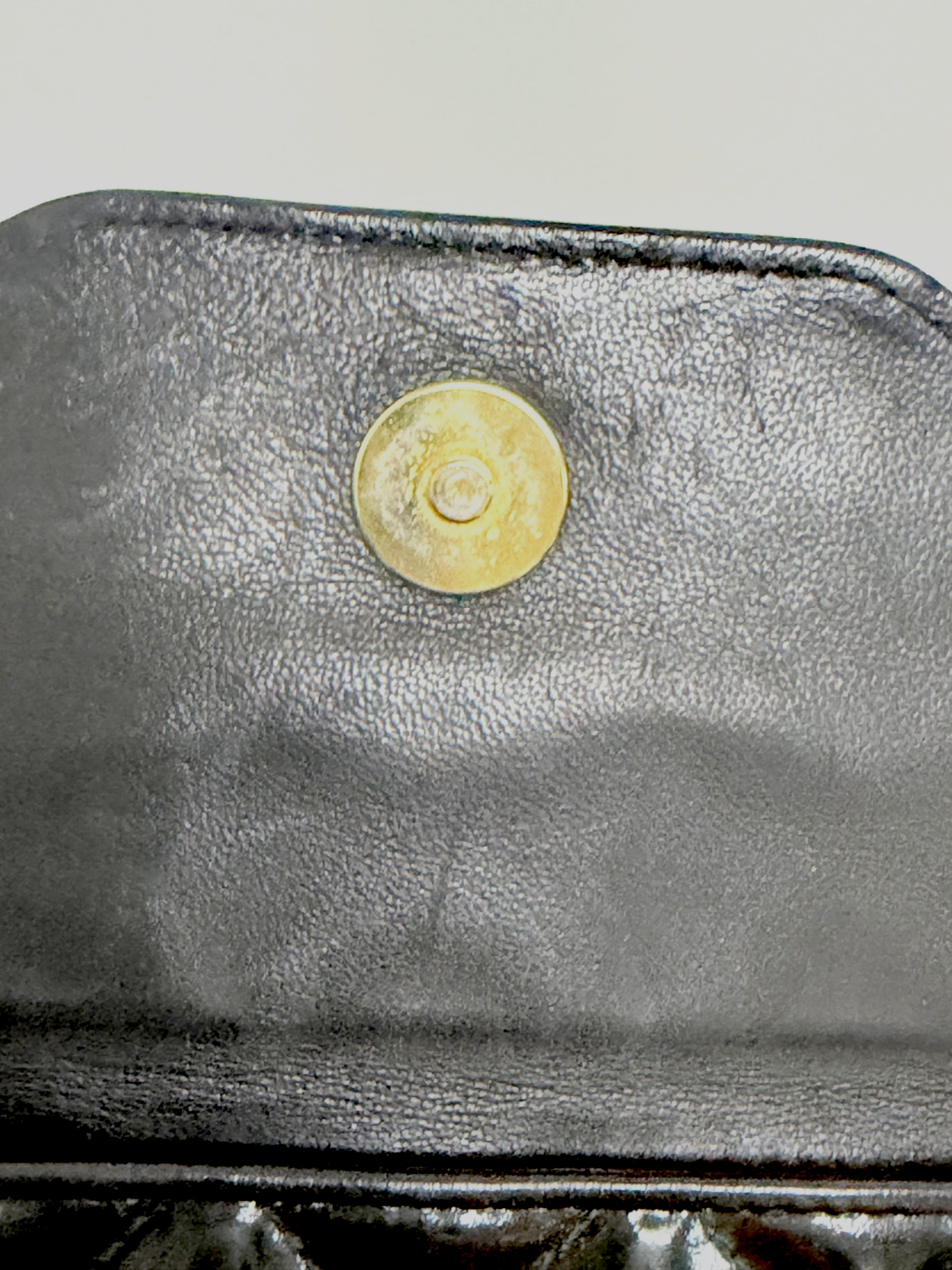 Lynn's Closet Boutique Chanel camera bag interior featuring a gold-tone magnetic snap closure on black leather