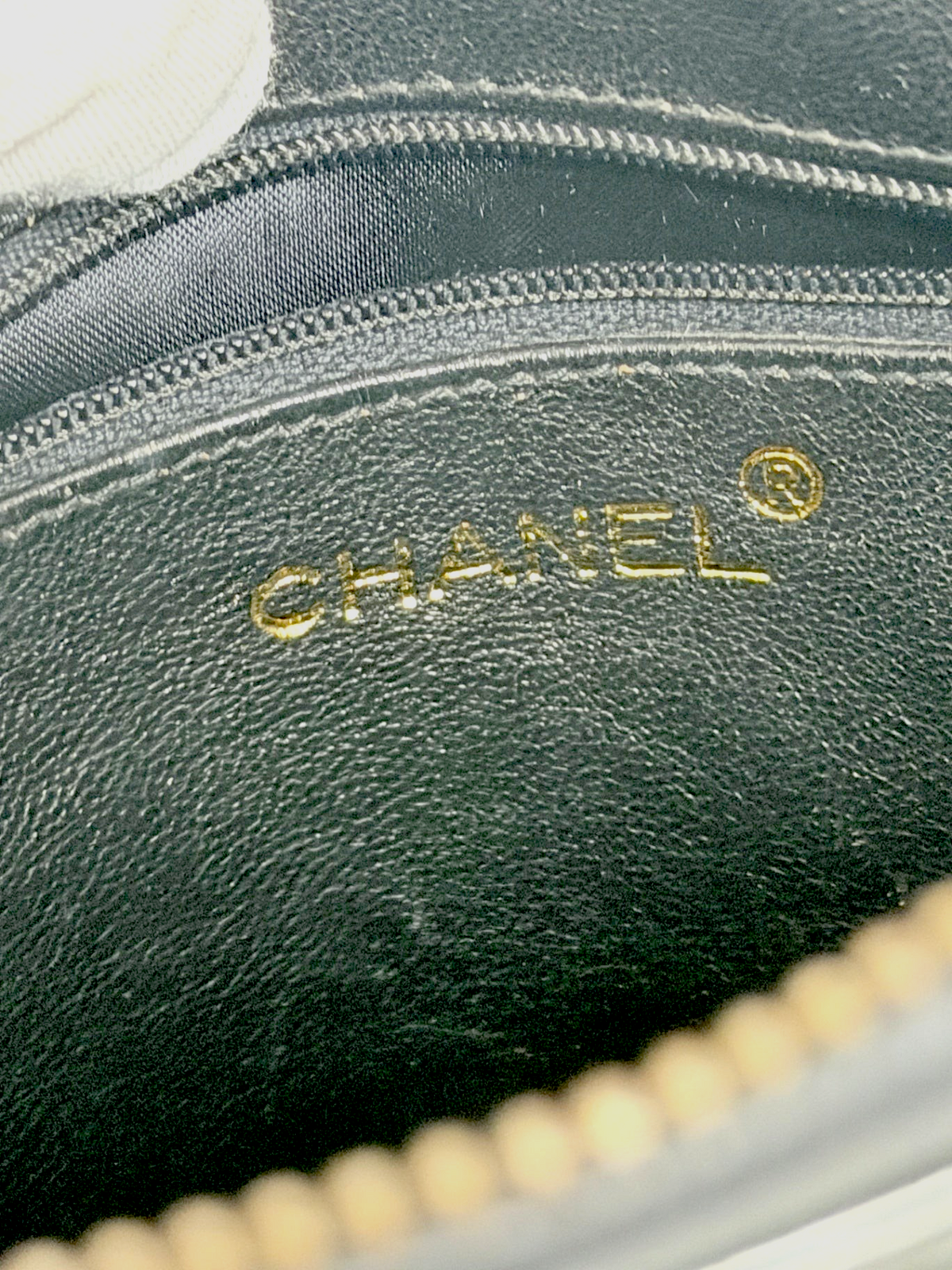 Interior of Lynn's Closet Boutique Chanel camera bag showing gold embossed logo on black leather lining