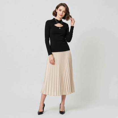 Lynn's Closet Boutique black Chiara Boni long-sleeve top with front cutout worn by a model with a pleated midi skirt