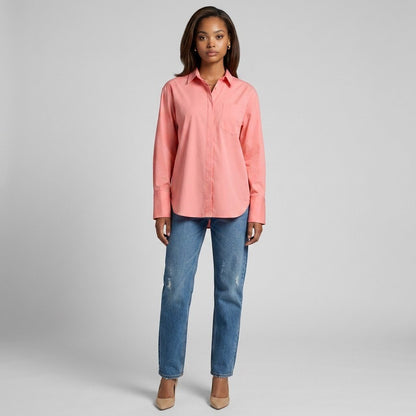 Model wearing a coral La Ligne button-down shirt with a chest pocket and blue jeans from Lynn's Closet Boutique