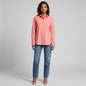 Model wearing a coral La Ligne button-down shirt with a chest pocket and blue jeans from Lynn's Closet Boutique
