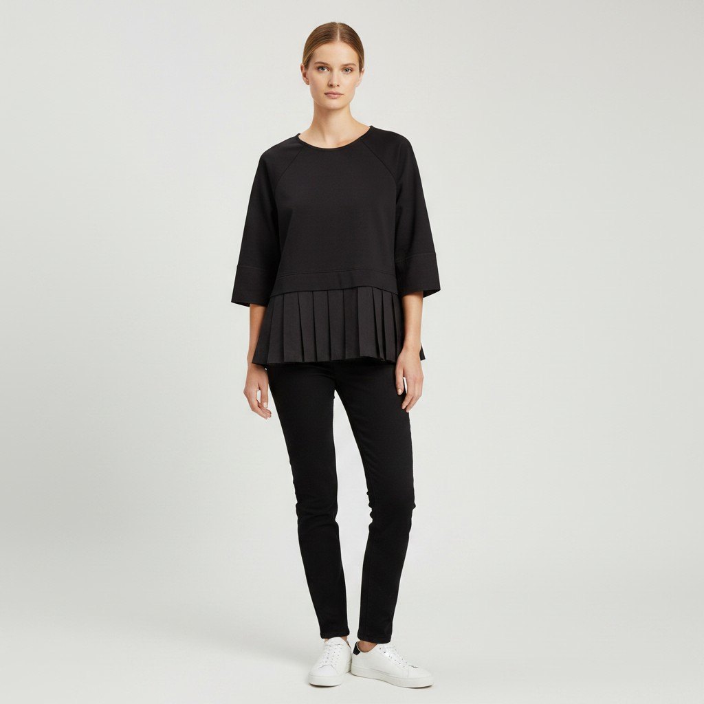 Lynn's Closet Boutique model wearing a black COS peplum top with three-quarter raglan sleeves and pleated hem