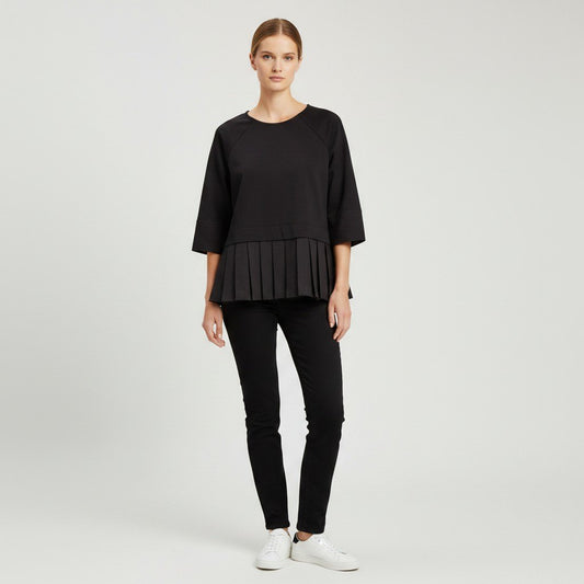 Lynn's Closet Boutique model wearing a black COS peplum top with three-quarter raglan sleeves and pleated hem