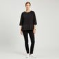 Lynn's Closet Boutique model wearing a black COS peplum top with three-quarter raglan sleeves and pleated hem