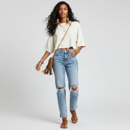 Lynn's Closet Boutique model wearing Free People light-wash distressed straight-leg jeans with a high-rise waist.