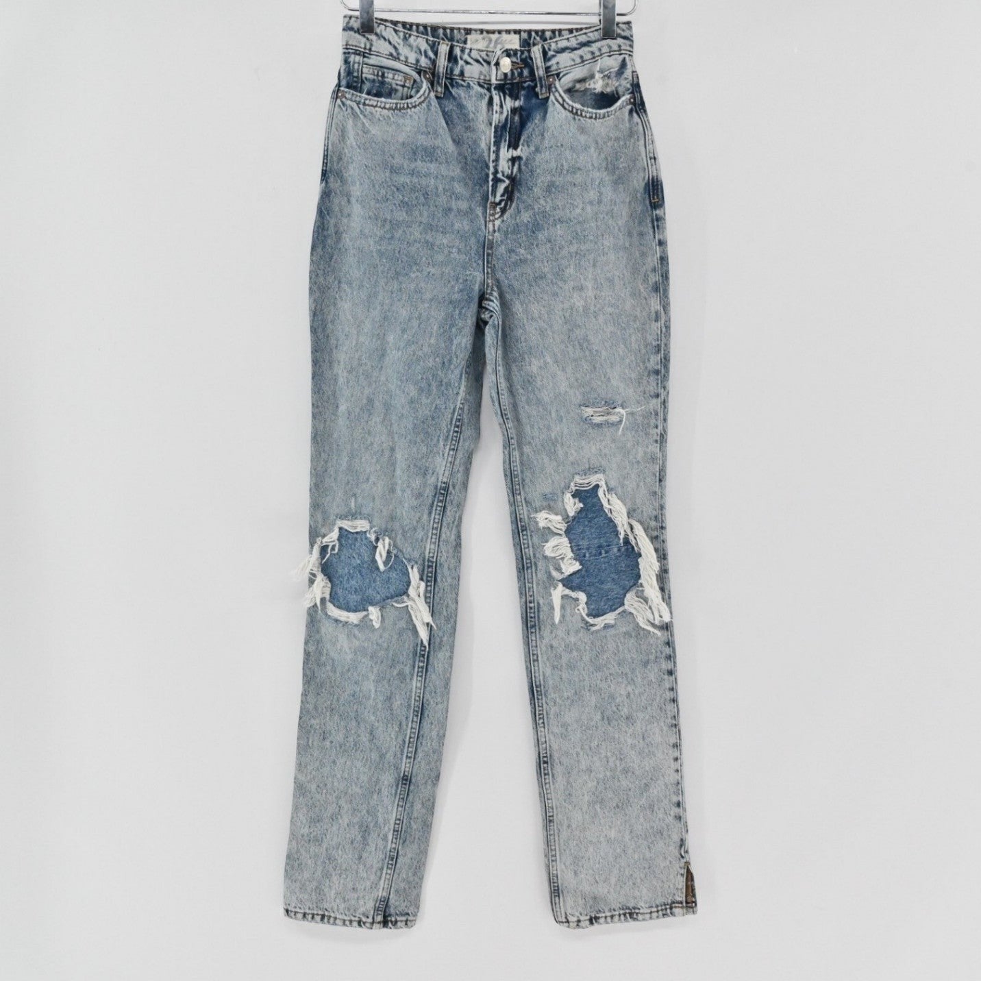 Lynn's Closet Boutique Free People light-wash distressed straight-leg jeans with knee rips and side-slit hems.