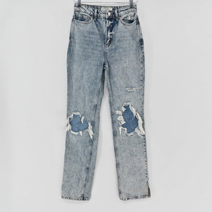 Lynn's Closet Boutique Free People light-wash distressed straight-leg jeans with knee rips and side-slit hems.