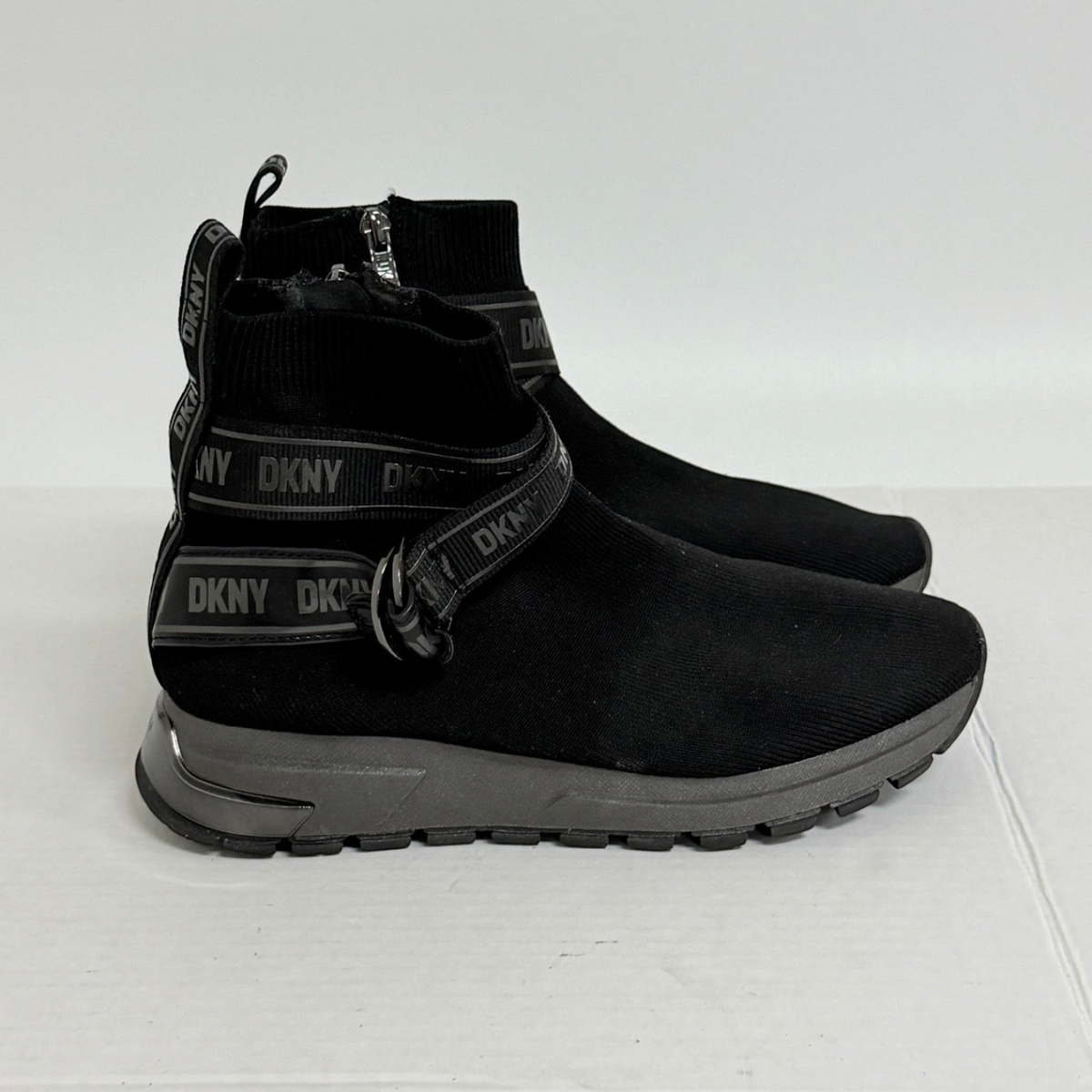 Lynn's Closet Boutique DKNY Miley black knit high-top sneakers with logo strap, side zip, and lugged rubber sole.