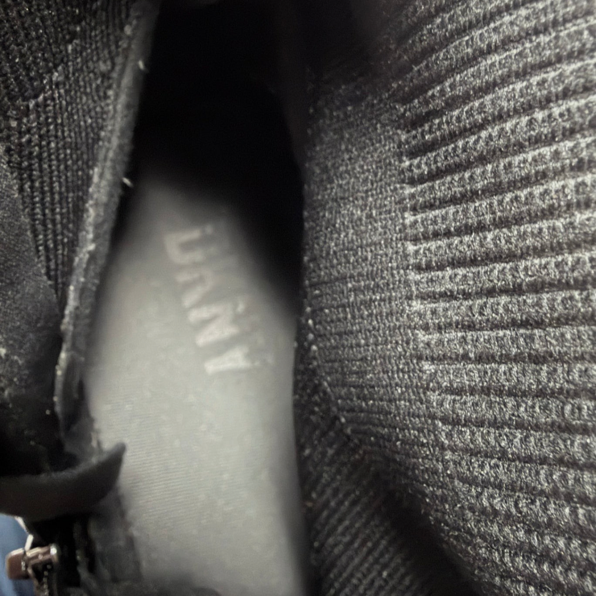 Interior view of Lynn's Closet Boutique DKNY Miley black knit hi-top sneaker showing the branded insole