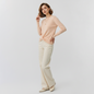 Model wearing Lynn's Closet Boutique DVF Kylee cream long-sleeve sweater with a front twist detail and cream trousers.