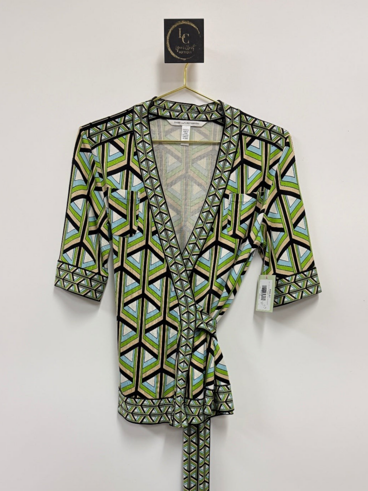 Lynn's Closet Boutique DVF silk wrap top in a green, blue, and black geometric print with a V-neck and tie waist.