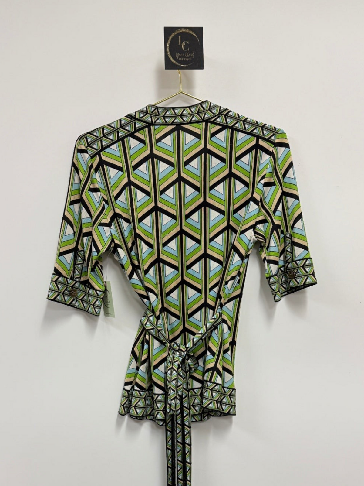 Lynn's Closet Boutique DVF silk wrap top with a green, blue, and black geometric print and elbow-length sleeves.